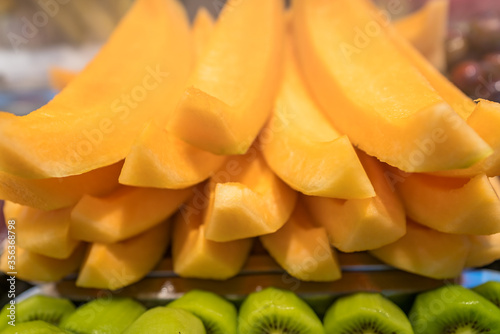 Delicious freshly cut kiwis and melons on sale on market