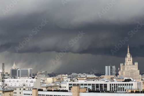 urban cityscape panorama day view of buildings, monuments, roofs, rooftops on a dark stormy sky and black rain clouds background. Moscow, Russia