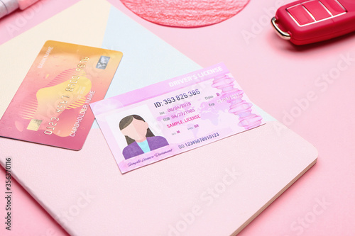 Driving license with notebook, car key and credit card on color background photo