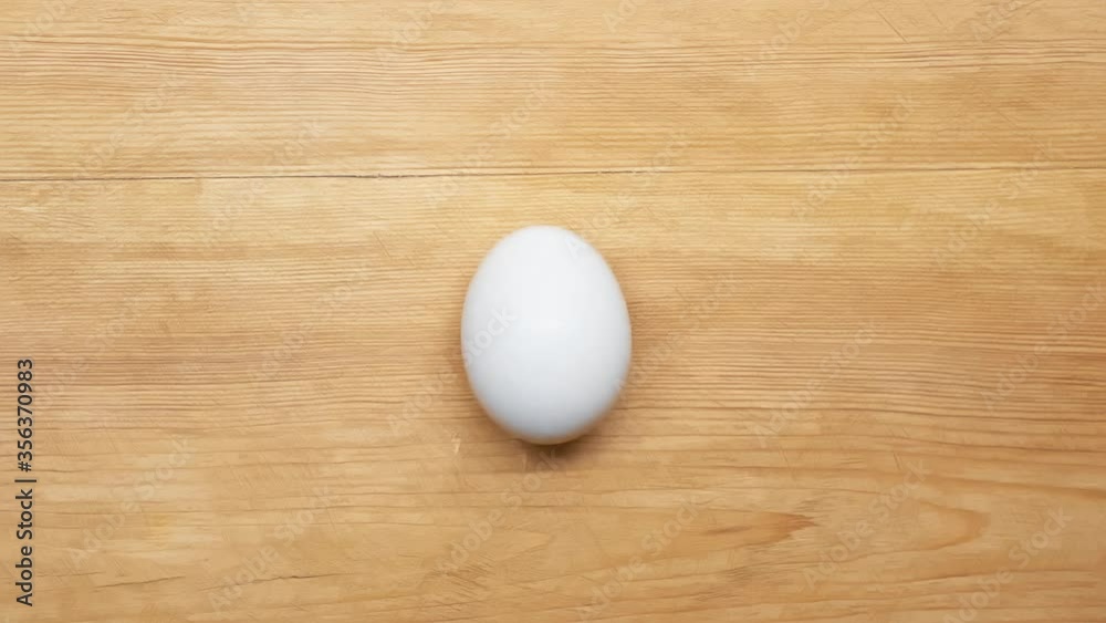 Top view of spinning egg on wooden surface Top view of spinning egg on wooden surface