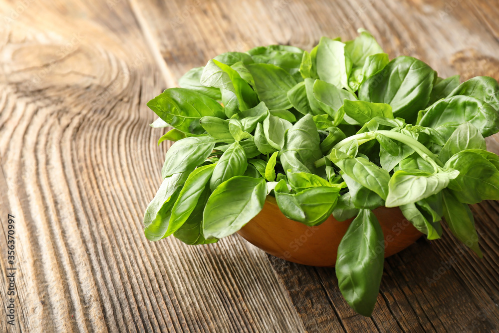 Bowl with fresh green basil on wooden background Bowl with fresh green basil on wooden background