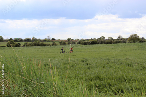 2 teenagers cycling in a countryside field in Yorkshire England 