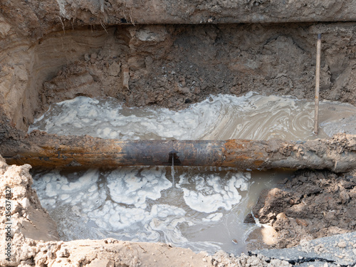 close-up of ruptured sewer rusty pipeline which cause sewage leakage stream and pollution Fototapet