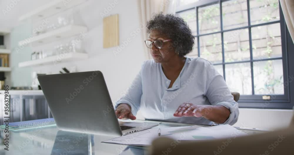 Senior mixed race woman using a laptop. Social distancing and self isolation in quarantine Senior mixed race woman using a laptop. Social distancing and self isolation in quarantine