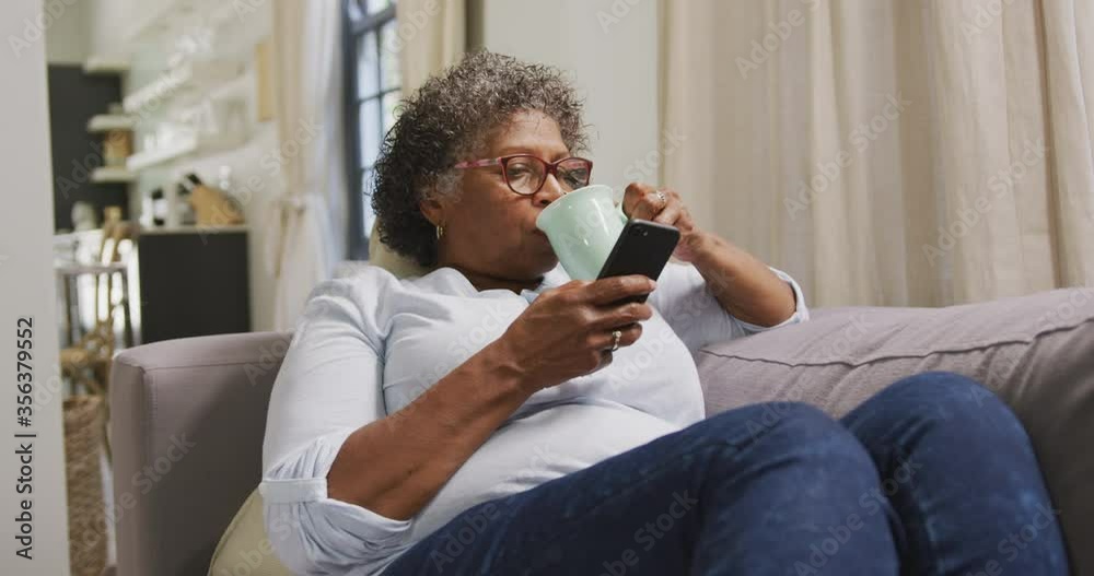 Senior mixed race woman using a smartphone. Social distancing and self isolation in quarantine