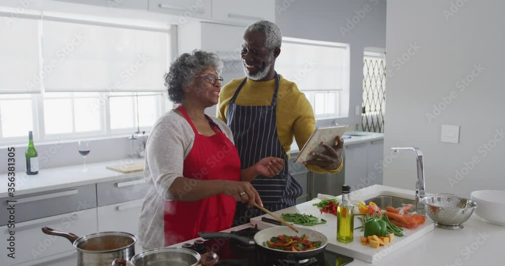 A senior African American couple cooking at home. Social distancing in quarantine.