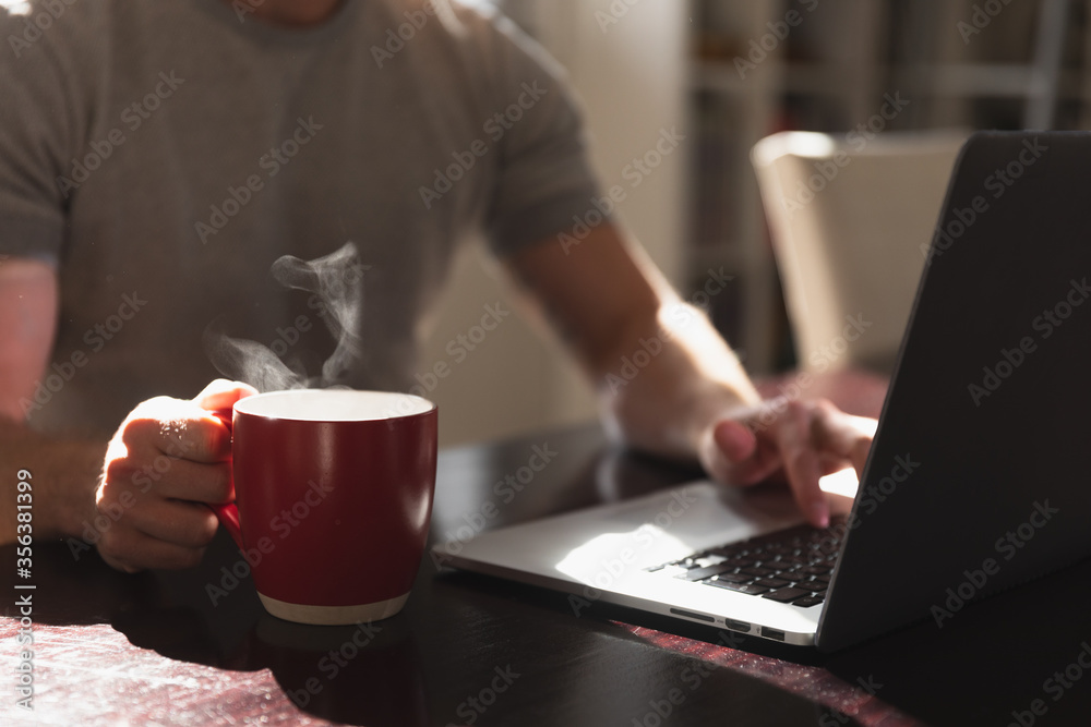 Mid section view man with coffee and a laptop Mid section view man with coffee and a laptop