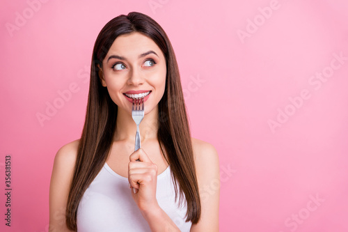 Photo of charming funny lady hold metal fork looking tempting empty space dream of tasty food dinner wear white singlet isolated pastel pink color background