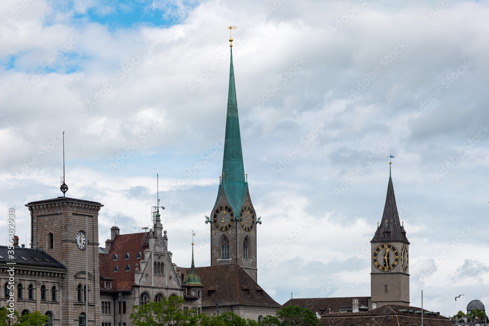 Old medieval church towers in Zurich city Switzerland summer day white clouds