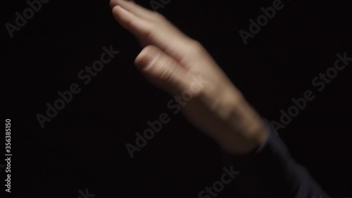 Doing hand wave gesture or funky dance move with hand - black background photo