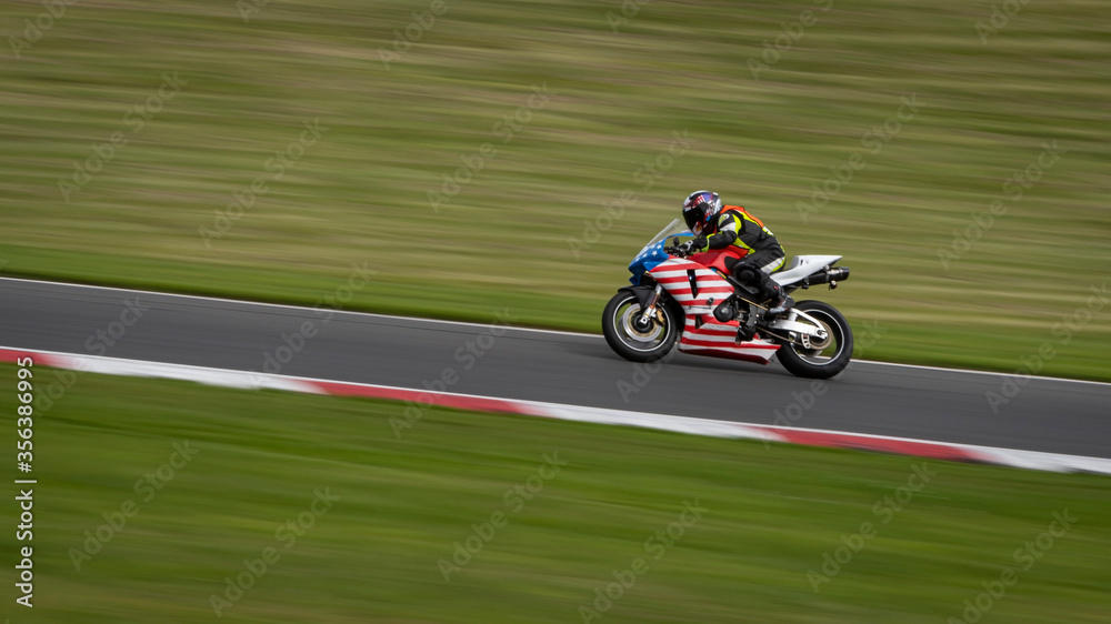 A panning shot of a racing bike cornering on a track