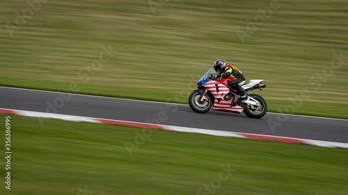 A panning shot of a racing bike cornering on a track © SnapstitchPhoto