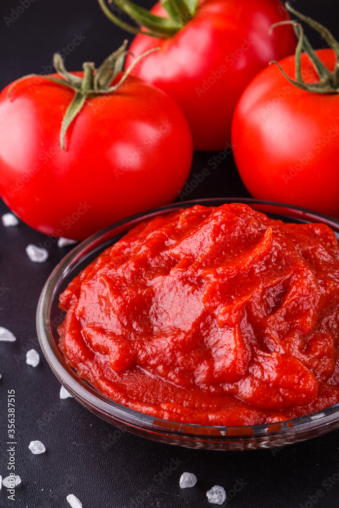 fresh natural tomato paste on black background fresh natural tomato paste on black background