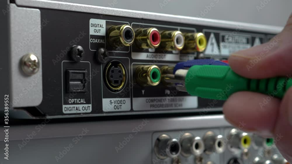 Male Hands Connecting Cables To A DVD Player. Close-Up. Component Video Cables Plug-In To Multimedia Electronic Device At Home.. Male Hands Connecting Cables To A DVD Player. Close-Up. Component Video Cables Plug-In To Multimedia Electronic Device At Home..