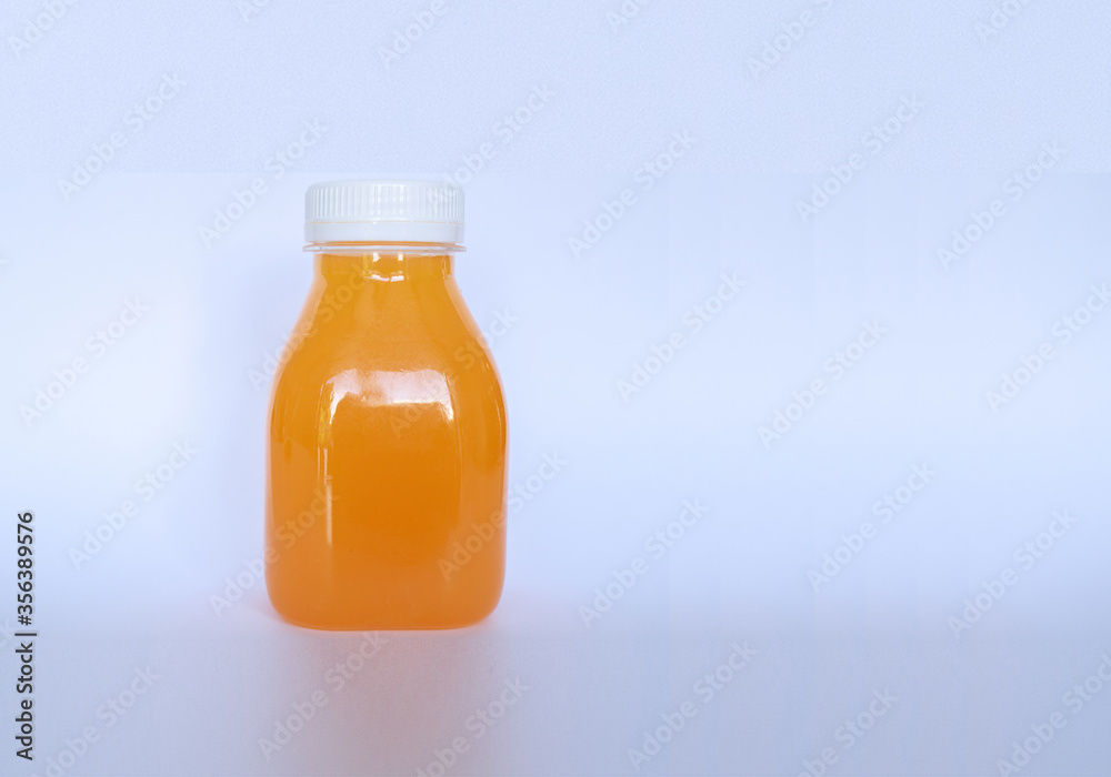 Small orange juice bottle for adding logo or branding isolated on abstract white background. Copy space. Close up and selective focus. Small orange juice bottle for adding logo or branding isolated on abstract white background. Copy space. Close up and selective focus.