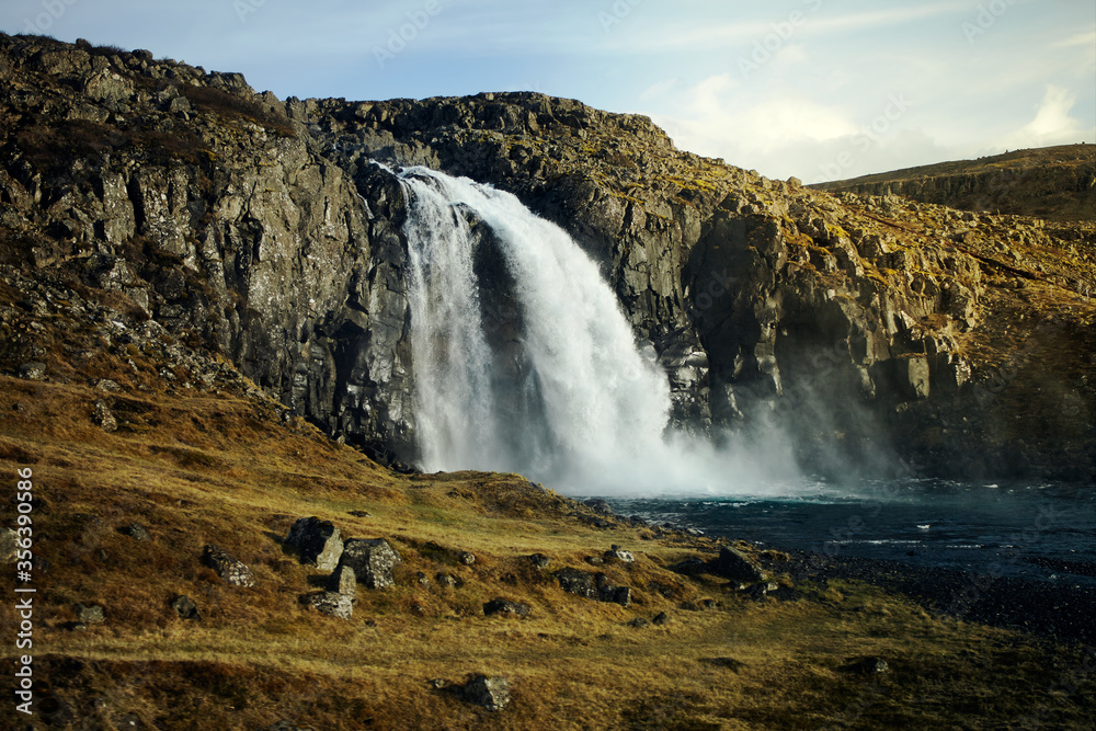 Wild waterfall in Iceland. Waterfall in the light of the setting sun, wild nature. nobody around.
