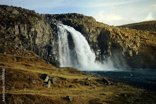 Wild waterfall in Iceland. Waterfall in the light of the setting sun  wild nature. nobody around.