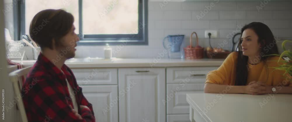 Unhappy couple talking about having problems in their relationship, sitting in the kitchen at home. Breaking up, cheating, divorce concept. Shallow DOF, Slow motion, BMPCC 4K Unhappy couple talking about having problems in their relationship, sitting in the kitchen at home. Breaking up, cheating, divorce concept. Shallow DOF, Slow motion, BMPCC 4K