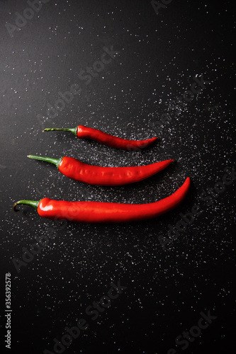 Red hot chili pepper and salt on black background