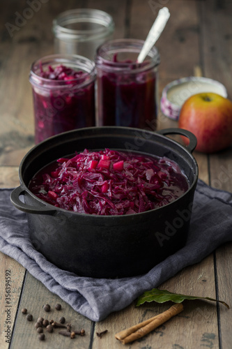 Cooking pot and preserving jars with apple cinnamon red cabbage photo