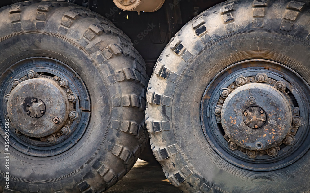 Huge old rubber tire of a large automotive vehicle. Selective focus. Huge old rubber tire of a large automotive vehicle. Selective focus.