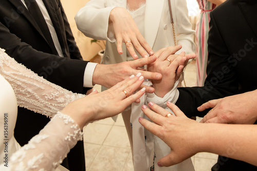 Bride  groom and group of wedding guests shows wedding rings