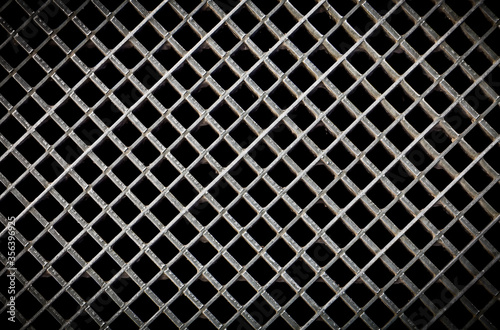 Iron ventilation grid lattice texture background. Silver gray metal pattern with square holes on black.