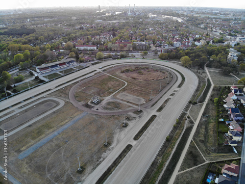 Aerial view of empty Karlshorst harness racing track, a historic 37-hectare facility for horse racing in the Berlin district of Lichtenberg at sunset.