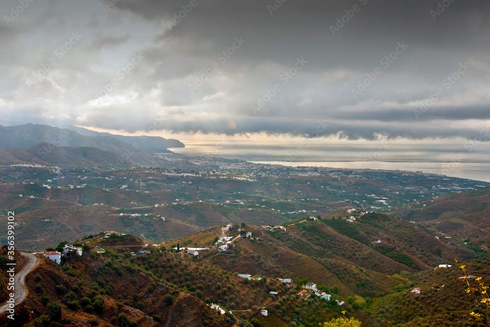 Storm clouds surrounding Nerja and The Moorish village of Frigiliana nestling in the mountains, Costa del Sol, Andalucia, Spain