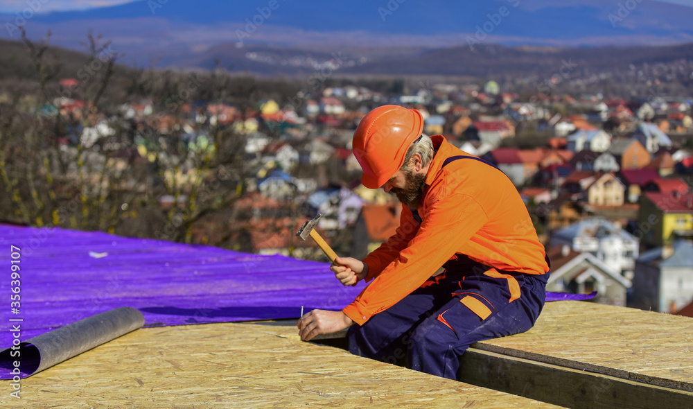Roofer constructing new roof. Builder roofing surface. Professional master repair roof. Flat roof installation. Construction building. Waterproof sheet materials. High altitude works. Heat insulation Roofer constructing new roof. Builder roofing surface. Professional master repair roof. Flat roof installation. Construction building. Waterproof sheet materials. High altitude works. Heat insulation