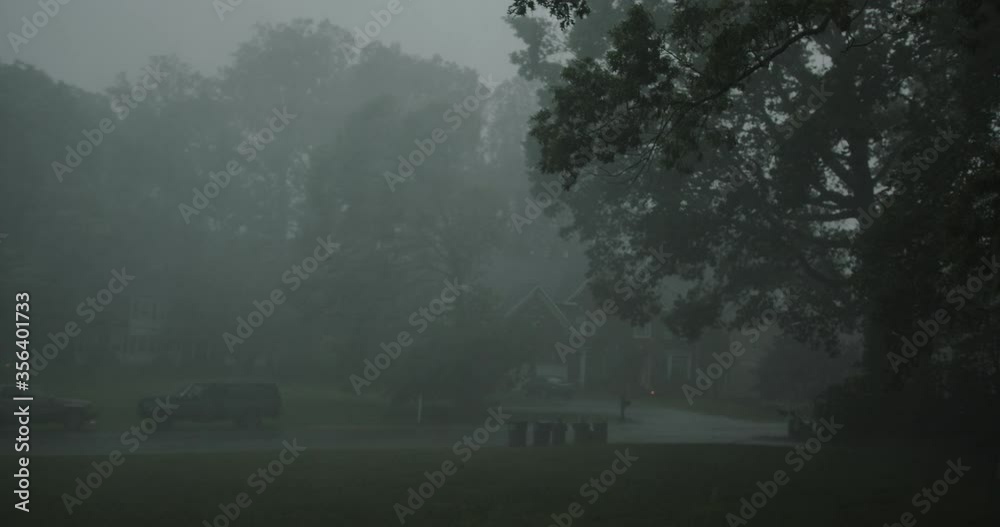 Torrential rain storm with lighting blows wildly through residential neighborhood - with audio