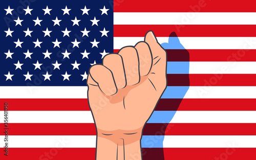 The concept of the struggle for rights and freedoms. Hand clenched into a fist against the backdrop of the American flag.