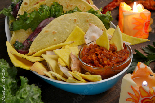 Mexican tacos with chicken, beef, paprika, lettuce, tomatoes and nachos, lime juice, tequila.