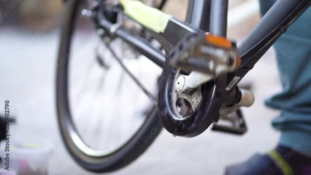 Strong Caucasian male mechanic hands rotating pedal spinning back tire of bicycle and stopping, close up static Strong Caucasian male mechanic hands rotating pedal spinning back tire of bicycle and stopping, close up static