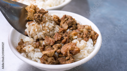 Braised meat rice, stewed beef over cooked rice in Tainan, Taiwan. Taiwanese famous traditional street food delicacy. Travel design concept, closeup.