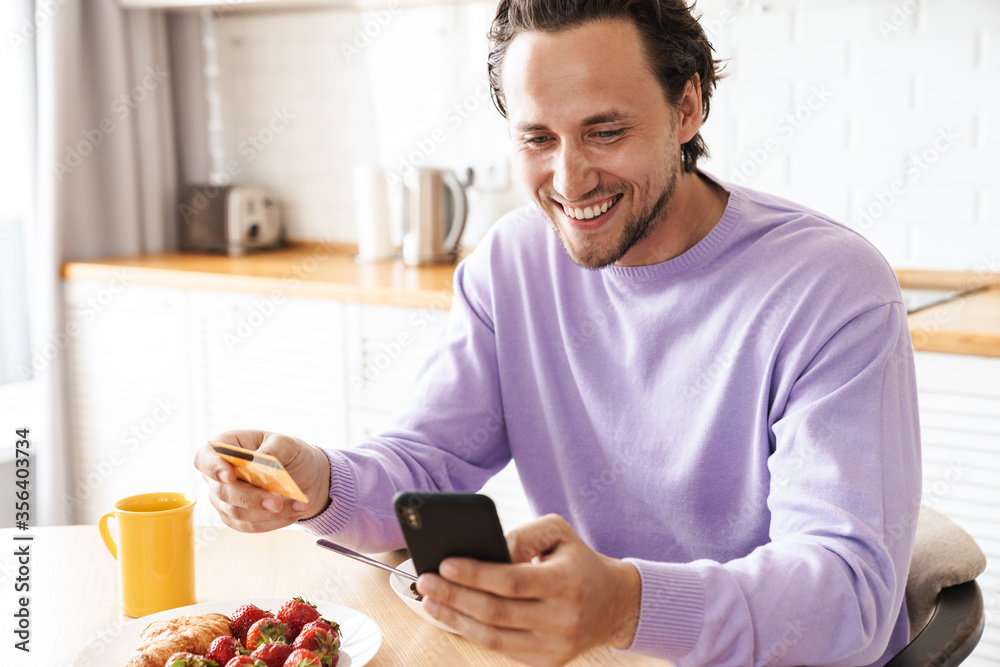 Attractive young man sitting at the kitchen table Attractive young man sitting at the kitchen table