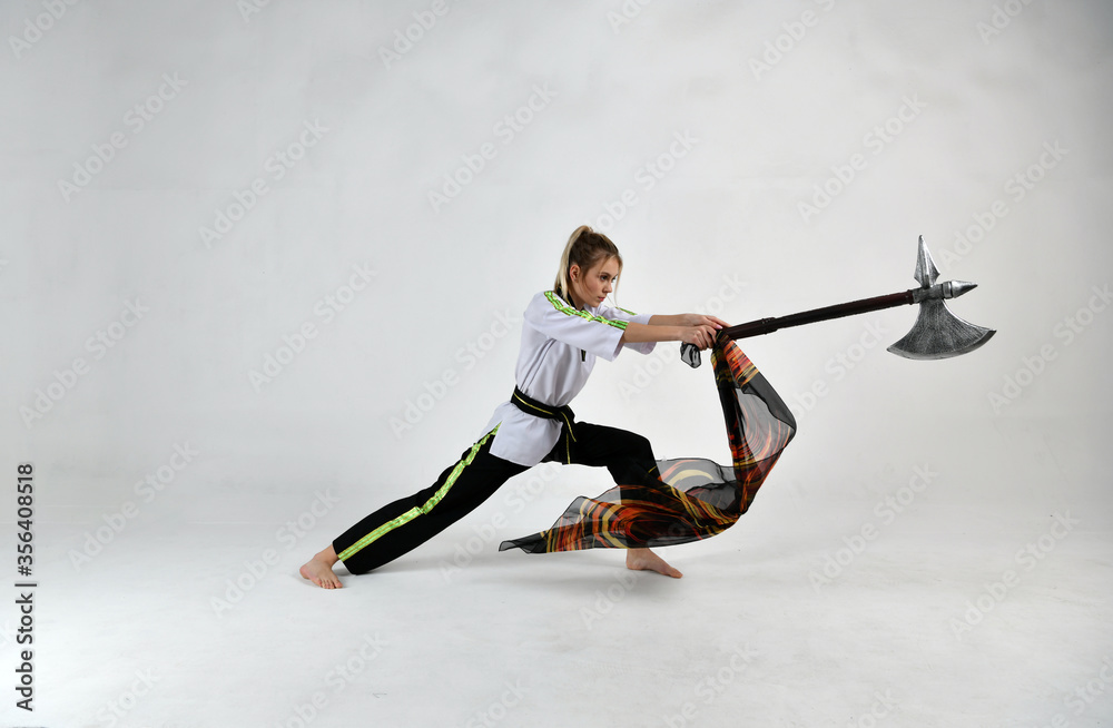 Fototapeta premium beautiful girl fighter in a white and black kimono with fighting swords