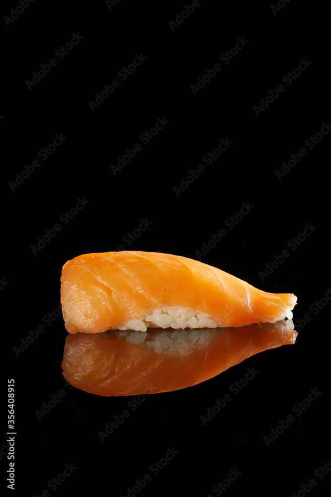 Japanese Cuisine - Appetizing Salmon Sushi Set, Nigiri. Philadelphia Sushi Roll - Maki Sushi with Philadelphia Cheese inside on mirror black background. Smoked salmon rolls served on a plate Japanese Cuisine - Appetizing Salmon Sushi Set, Nigiri. Philadelphia Sushi Roll - Maki Sushi with Philadelphia Cheese inside on mirror black background. Smoked salmon rolls served on a plate