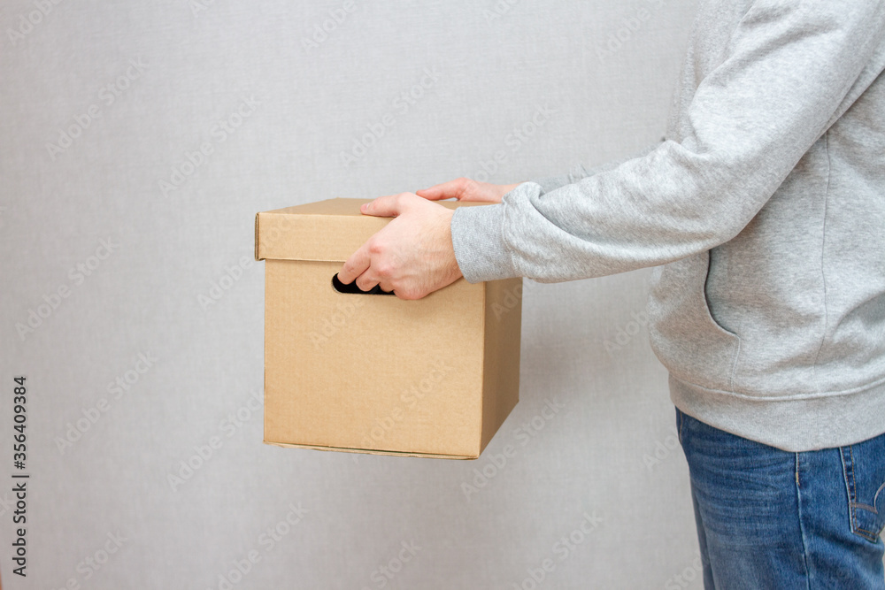 Delivery Man Holds Cardboard Box Package. Fast Delivery Delivery Man Holds Cardboard Box Package. Fast Delivery