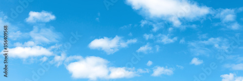 Blue summer sky with cumulus white clouds. Low angle shot. Banner for website.