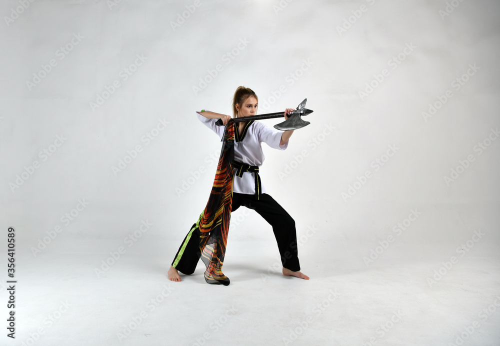 beautiful girl in a white-black suit does exercises with a battle ax and a scarf beautiful girl in a white-black suit does exercises with a battle ax and a scarf