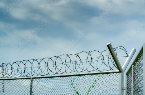 Prison security fence. Barbed wire security fence. Razor wire jail fence. Barrier border. Boundary security wall. Prison for arrest criminals or terrorists. Private area. Military zone concept.