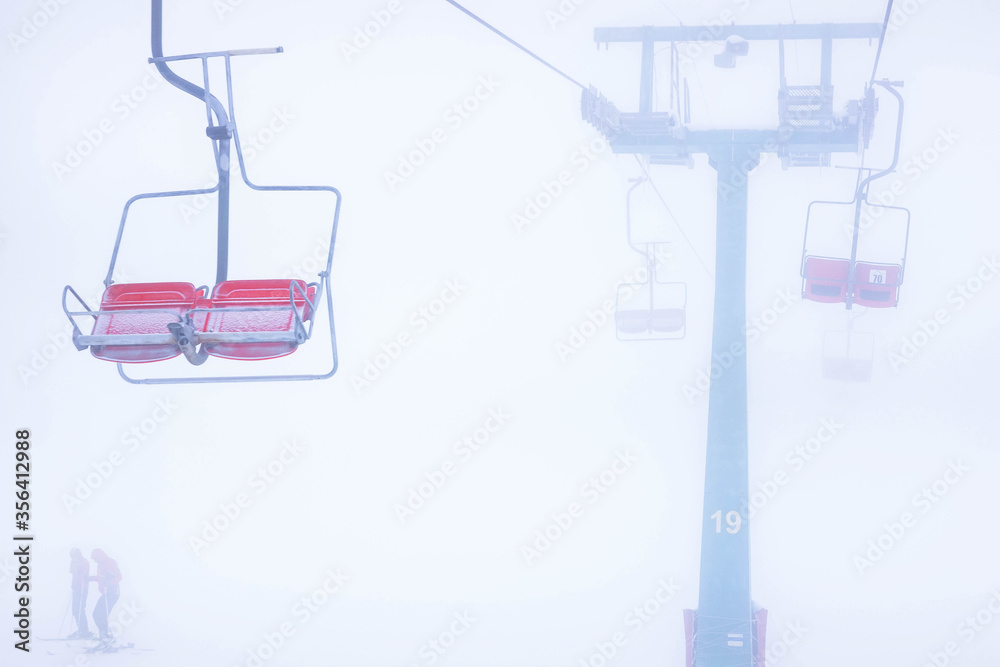 Chairlift in the mountains, winter view of the spores, rest in the mountains, skiing, red seats Chairlift in the mountains, winter view of the spores, rest in the mountains, skiing, red seats