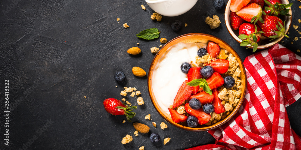 Greek yogurt granola with fresh berries on black stone table. Greek yogurt granola with fresh berries on black stone table.
