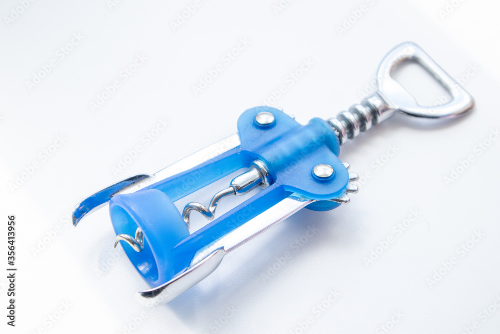 Wine bottle opener. Blue corkscrew for wine on white wooden background. Wine bottle opener. Blue corkscrew for wine on white wooden background.