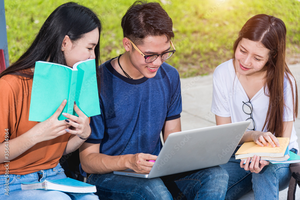 Happy young Asian group students studying sitting on footpath outdoors consult learning together with laptop computer, Education back to college concept Happy young Asian group students studying sitting on footpath outdoors consult learning together with laptop computer, Education back to college concept