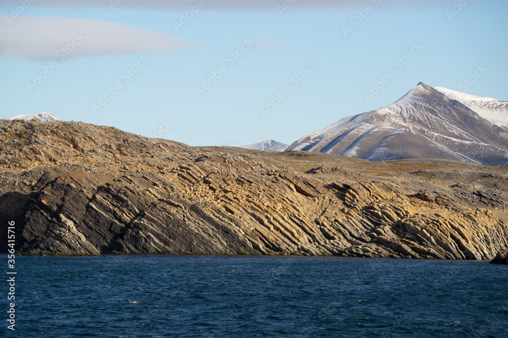 Special and very old rock formation on Spitsbergen with mountains in the background