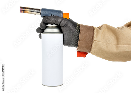 Powerful welding gas torch in man hand in black protective glove and brown uniform isolated on white background