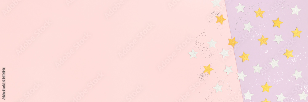 Silver and gloden stars confetti scattered on a pink pastel background. Banner with place for text.