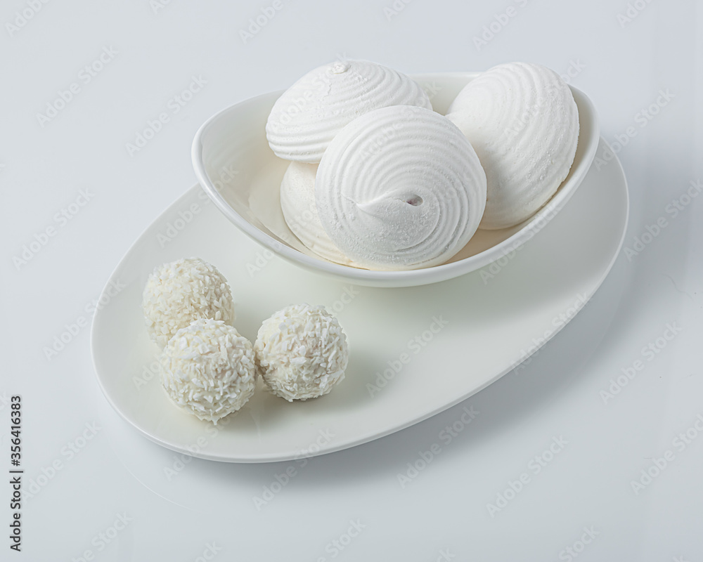 White marshmallows and candies with coconut on a white bowl White marshmallows and candies with coconut on a white bowl